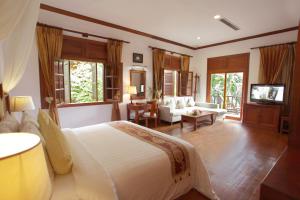 ein Schlafzimmer mit Bett und ein Wohnzimmer in der Unterkunft Sokhalay Angkor Villa Resort in Siem Reap
