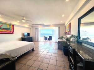 a bedroom with a bed and a view of the ocean at Hotel Delfin Puerto Vallarta in Puerto Vallarta