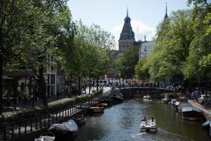 a river with boats in it with people on it at Hotel 717 in Amsterdam