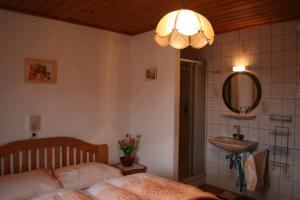 Schlafzimmer mit einem Bett, einem Waschbecken und einem Spiegel in der Unterkunft Ferienwohnungen Grabnerbauer in Mondsee