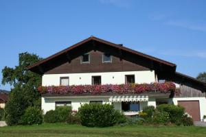 una casa con flores a un lado. en Ferienwohnungen Grabnerbauer en Mondsee