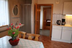 eine Küche mit einem Tisch und einer Blumenvase darauf in der Unterkunft Ferienwohnungen Grabnerbauer in Mondsee