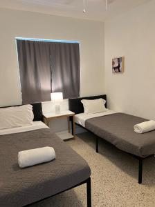 a room with two beds and a table with a lamp at Broadwaysuites Downtown By RocketStay in Miami