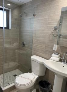 a bathroom with a toilet and a sink and a shower at Broadwaysuites Downtown By RocketStay in Miami
