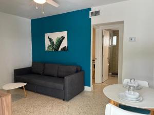 a living room with a couch and a blue wall at Broadwaysuites Downtown By RocketStay in Miami