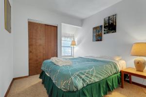 a bedroom with a bed and a table and a window at Year Round Condo- Sleeps 5! - Tamarack #17 in Bear Valley