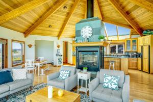 a living room with a fireplace and wooden ceilings at Pelican House in Fort Bragg