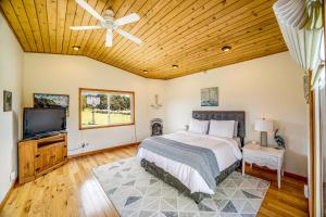 a bedroom with a bed and a flat screen tv at Pelican House in Fort Bragg