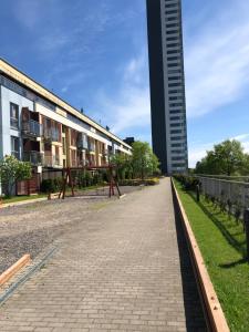una acera de ladrillo junto a un edificio con un edificio alto en Vezas Apartment 3beds en Klaipėda