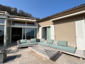 a patio with two blue couches and a table at Brissago: Villa Claudia in Brissago