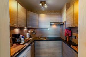 a kitchen with wooden cabinets and a sink at Splendid Seaview - Ostend Luxury Studio 4 persons at beach and sea in Ostend