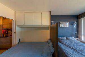 a bedroom with a bed and a blue wall at Splendid Seaview - Ostend Luxury Studio 4 persons at beach and sea in Ostend