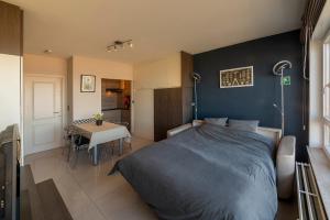 a bedroom with a bed and a table and a kitchen at Splendid Seaview - Ostend Luxury Studio 4 persons at beach and sea in Ostend
