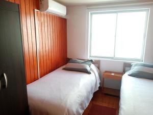 a small bedroom with two beds and a window at El Rincon de los Poetas in Nueva Imperial