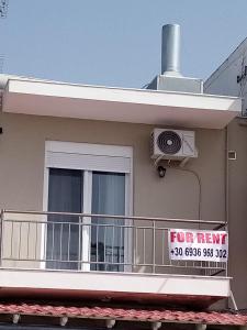 a for rent sign on a balcony of a house at Katerina apartment in Nea Plagia