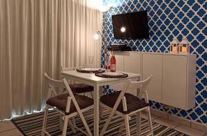 uma sala de jantar com uma mesa branca e cadeiras em Studio At The Beach em Alvor
