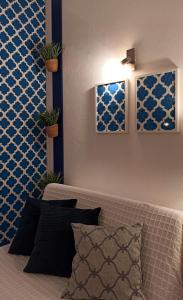 a bedroom with blue and white walls and a couch at Studio At The Beach in Alvor