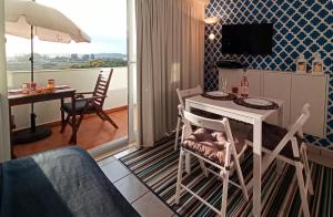 a living room with a table and chairs and a television at Studio At The Beach in Alvor