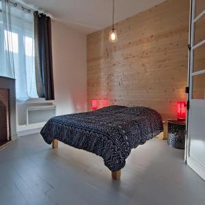 a bedroom with a bed with a wooden wall at LAMATACAM, T3, RDC, 2 chamb. centre Argelès Gazost in Argelès-Gazost