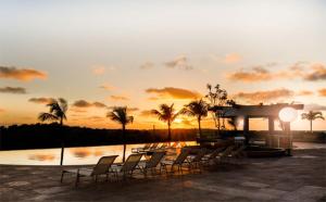 a group of chairs sitting next to a body of water at Salinas Park Resort in Salinópolis
