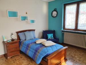 um quarto com uma cama e um relógio na parede em I Pini - appartamento em Boves