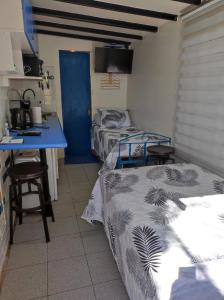 a room with two beds and a desk and a table at Terminal Pajarito in Santiago