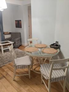 een eetkamer met een glazen tafel en stoelen bij Apartament Rezydencja Bursztyn in Świnoujście