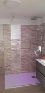 a bathroom with a shower with a glass wall at La Casina sul mare in Giovinazzo +2 photos
