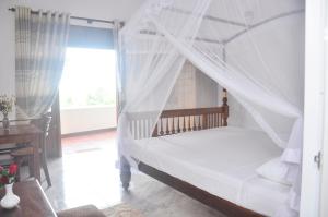 a bedroom with a bed with a mosquito net at Supun Villa in Bentota