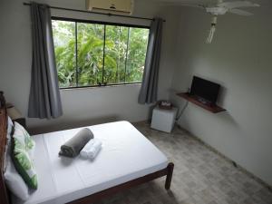 パラチにあるPousada Tropicália Paratyのベッドルーム(白いベッド1台、窓付)