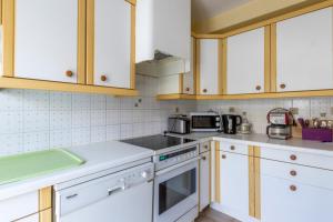a kitchen with white appliances and wooden cabinets at Nice Duplex With Garden Terrace And Garage in Six-Fours-les-Plages