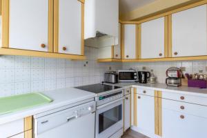 uma cozinha com electrodomésticos brancos e armários de madeira em Nice Duplex With Garden Terrace And Garage em Six-Fours-les-Plages