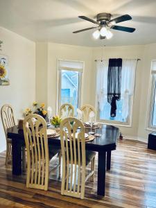 a dining room table with chairs and a ceiling fan at Cheerful residence in Niagara Falls