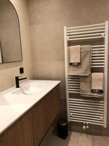 ein Badezimmer mit einem Waschbecken, einem Spiegel und Handtüchern in der Unterkunft De Betze - Country Life in Geetbets