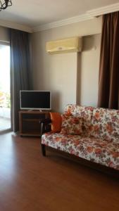 a living room with a couch and a tv at Villa Beach in Kusadası