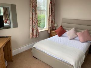 a bedroom with a bed with pillows and a mirror at Dolphin Hotel in Bovey Tracey
