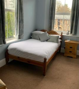 a bed sitting in a room with a window at Dolphin Hotel in Bovey Tracey