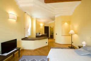 ein Hotelzimmer mit einem Bett und einem Fernseher in der Unterkunft Piazza Azuni 18 Guest House in Sassari