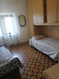 um pequeno quarto com 2 camas e uma janela em Casa Venelia em Monti di Licciana Nardi