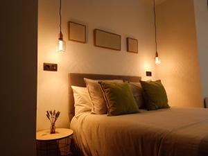 1 dormitorio con cama con almohadas y luces verdes en Residencial Gijón Centro, en Gijón