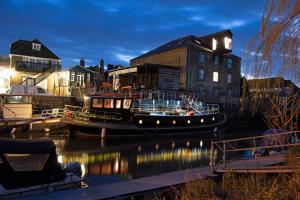 ein Boot liegt im Wasser neben einem Gebäude in der Unterkunft Waterman's Cottage in Kent