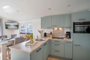 a kitchen with white cabinets and a counter top at Ferienhaus "Ostseeperle" mit kostenfreier Saunanutzung, Grundstück Umzäunt in Scharbeutz