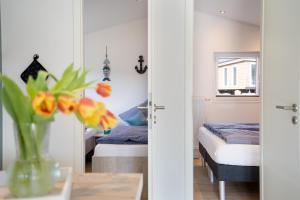 ein Schlafzimmer mit einem Bett und einer Vase mit Blumen in der Unterkunft Ferienhaus "Ostseeperle" mit kostenfreier Saunanutzung, Grundstück Umzäunt in Scharbeutz