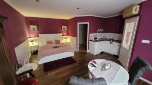 a purple bedroom with a bed and a table at Guest House Romantika Panzio in Gyula