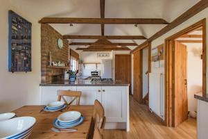 a kitchen and dining room with a wooden table at The Nest by Bloom Stays in Dymchurch