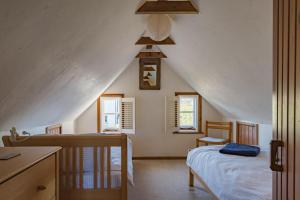 a attic bedroom with two beds and a ceiling at The Nest by Bloom Stays in Dymchurch