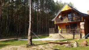 a house with a hammock in front of it at Domek Chańcza in Chańcza
