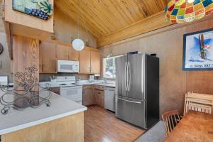 a kitchen with a stainless steel refrigerator and white appliances at Centrally Located and Dog Friendly! - Home #36 in Bear Valley +25 photos