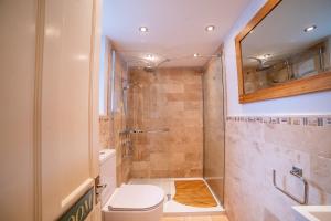 ein Badezimmer mit Toilette und Dusche in der Unterkunft Waterman's Cottage in Kent + 5 Fotos