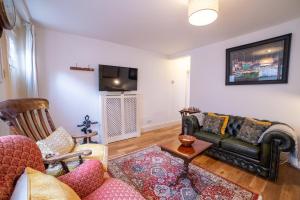 ein Wohnzimmer mit Sofa und Fernseher in der Unterkunft Waterman's Cottage in Kent